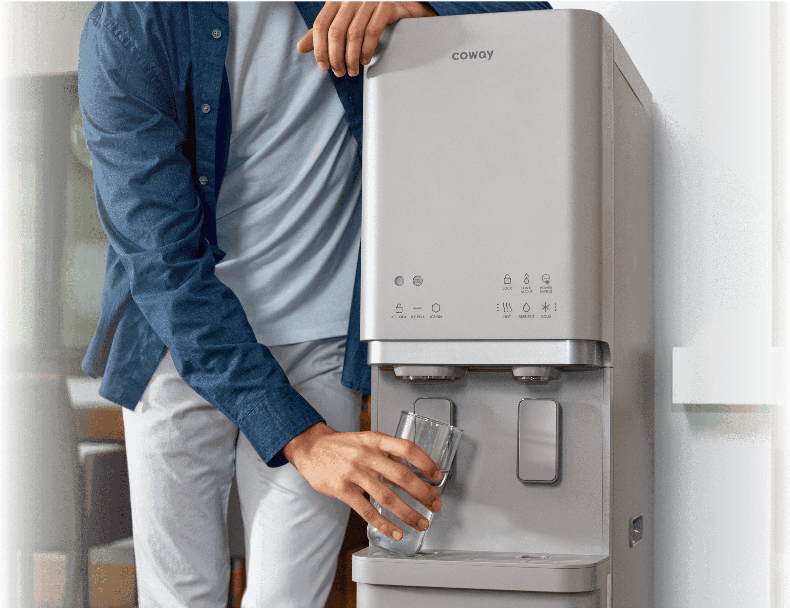코웨이 CHPI-620L Plus 정수기에서 물을 받는 남성